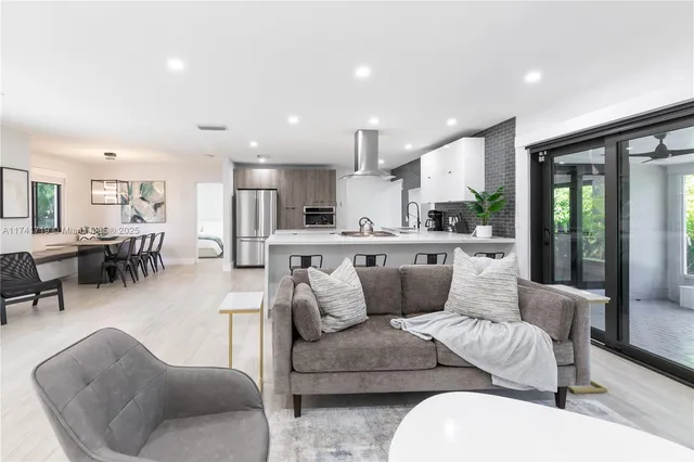 a living room with furniture and a view of kitchen
