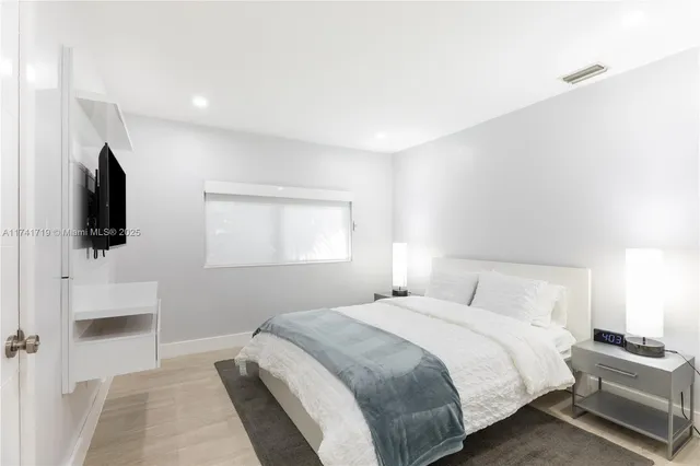 a bedroom with a bed and a flat screen tv