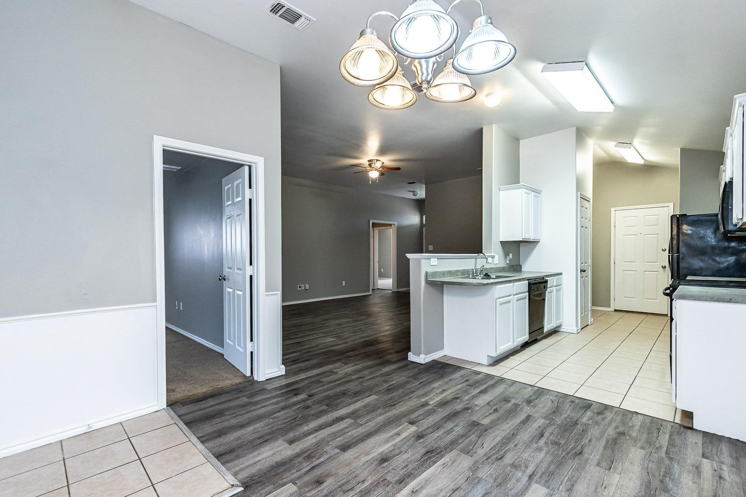 2006 100th Street Lubbock, TX 79423 - Photo 13 of 31 a view of a kitchen center island wooden floor and stainless steel appliances