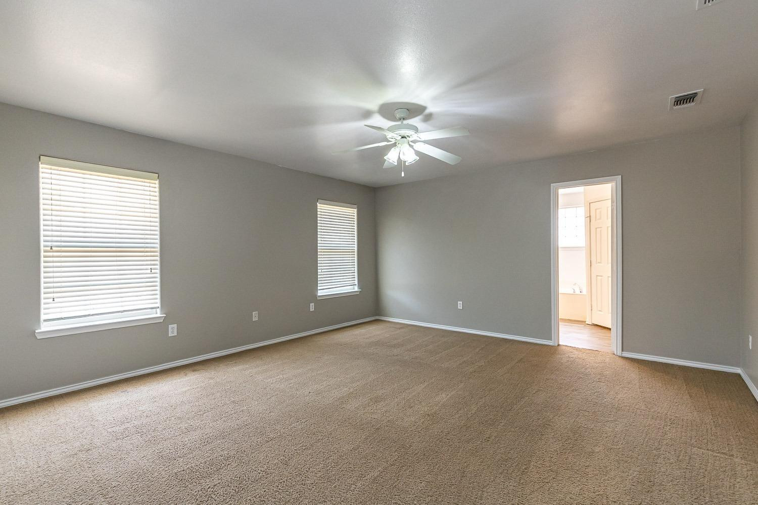 2006 100th Street Lubbock, TX 79423 - Photo 14 of 31 an empty room with windows and ceiling fan