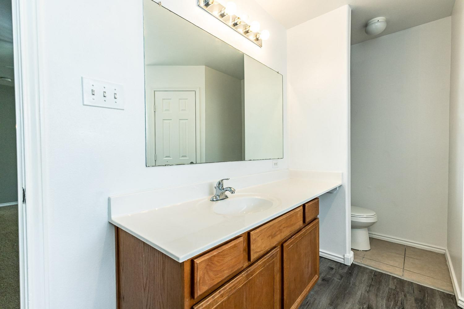 2006 100th Street Lubbock, TX 79423 - Photo 16 of 31 a bathroom with a sink toilet and a mirror
