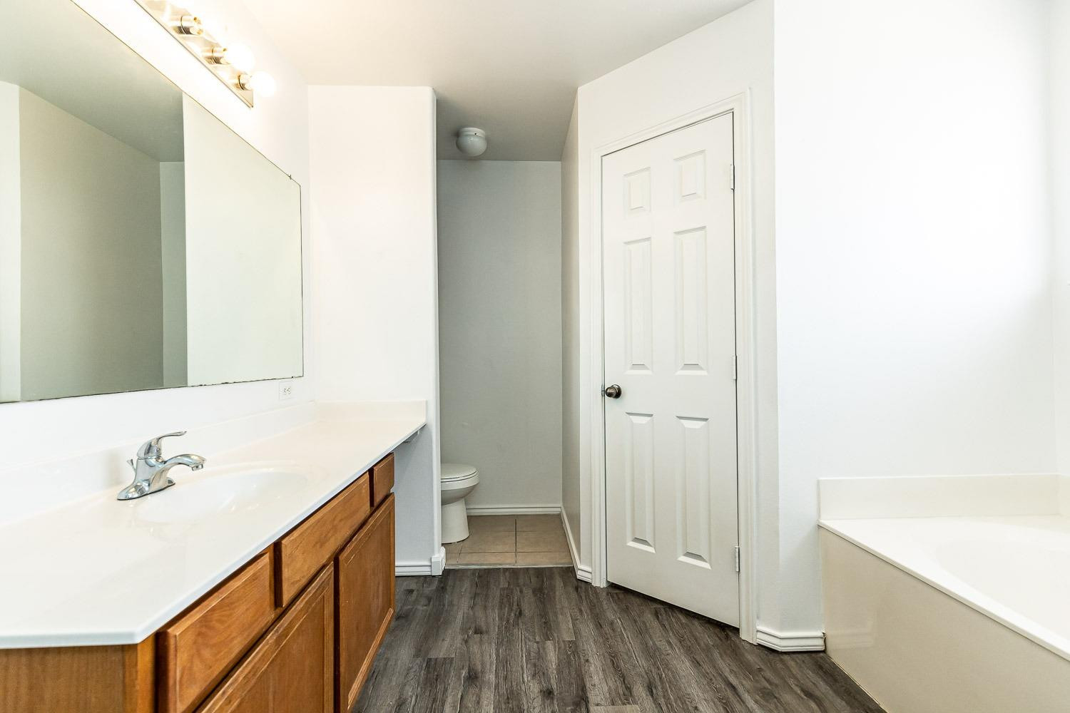 2006 100th Street Lubbock, TX 79423 - Photo 17 of 31 a bathroom with a bathtub and a sink