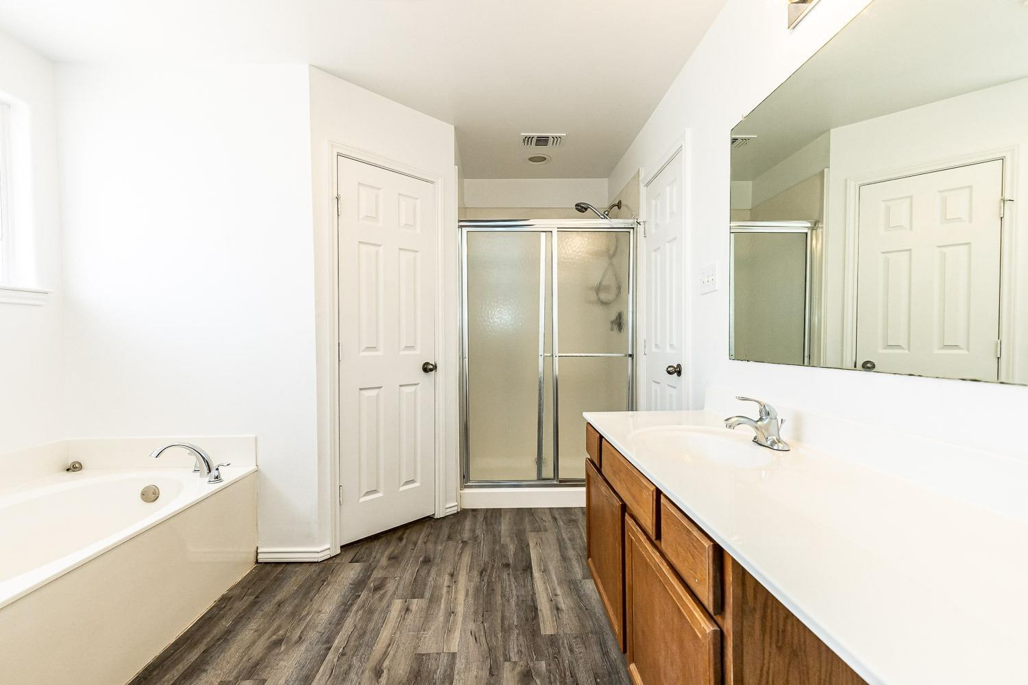 2006 100th Street Lubbock, TX 79423 - Photo 19 of 31 a bathroom with a tub sink and mirror