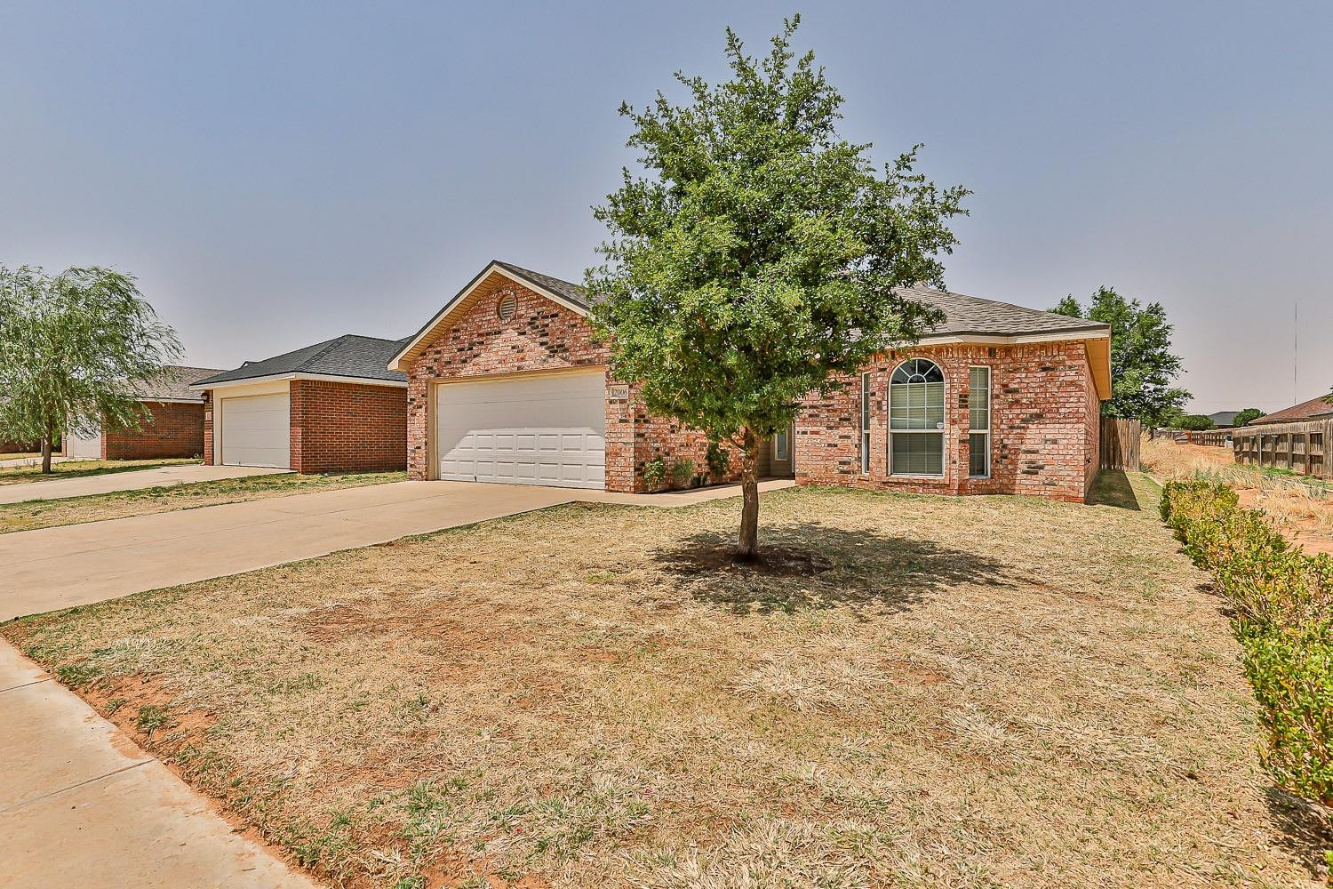 2006 100th Street Lubbock, TX 79423 - Photo 2 of 31 a front view of a house with a yard and garage