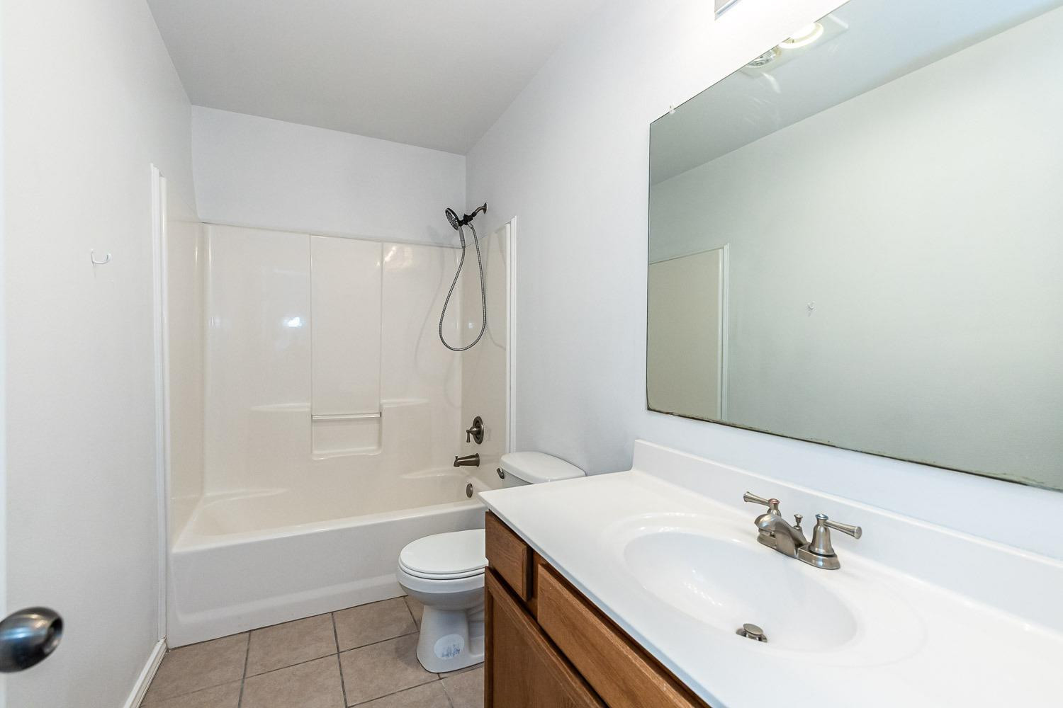 2006 100th Street Lubbock, TX 79423 - Photo 23 of 31 a bathroom with a sink a toilet and shower