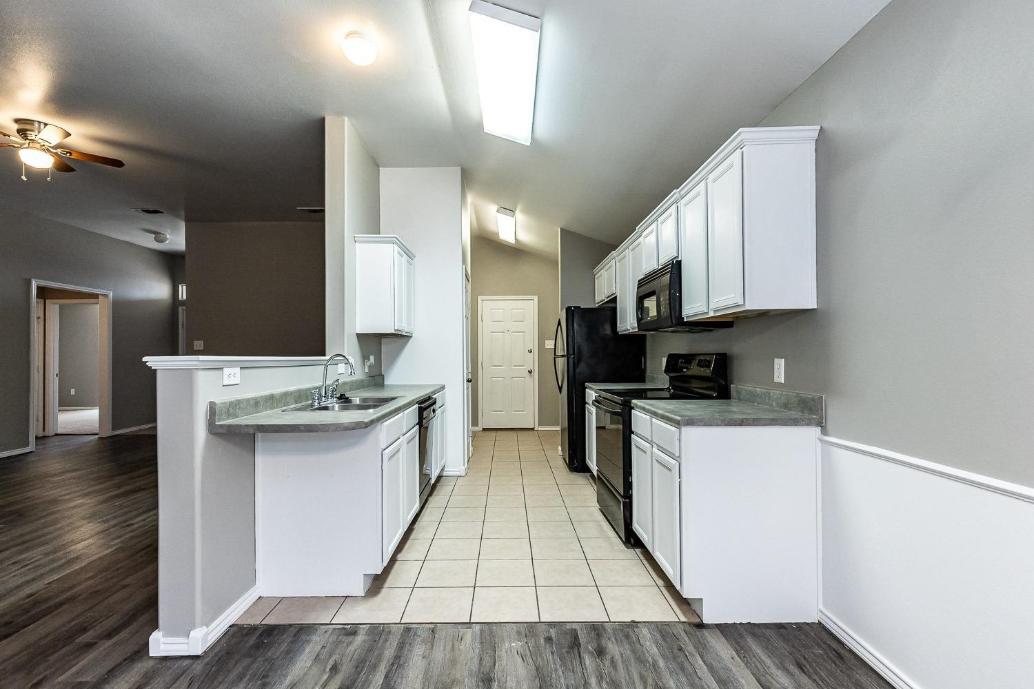 2006 100th Street Lubbock, TX 79423 - Photo 7 of 31 a kitchen with a sink stove and cabinets