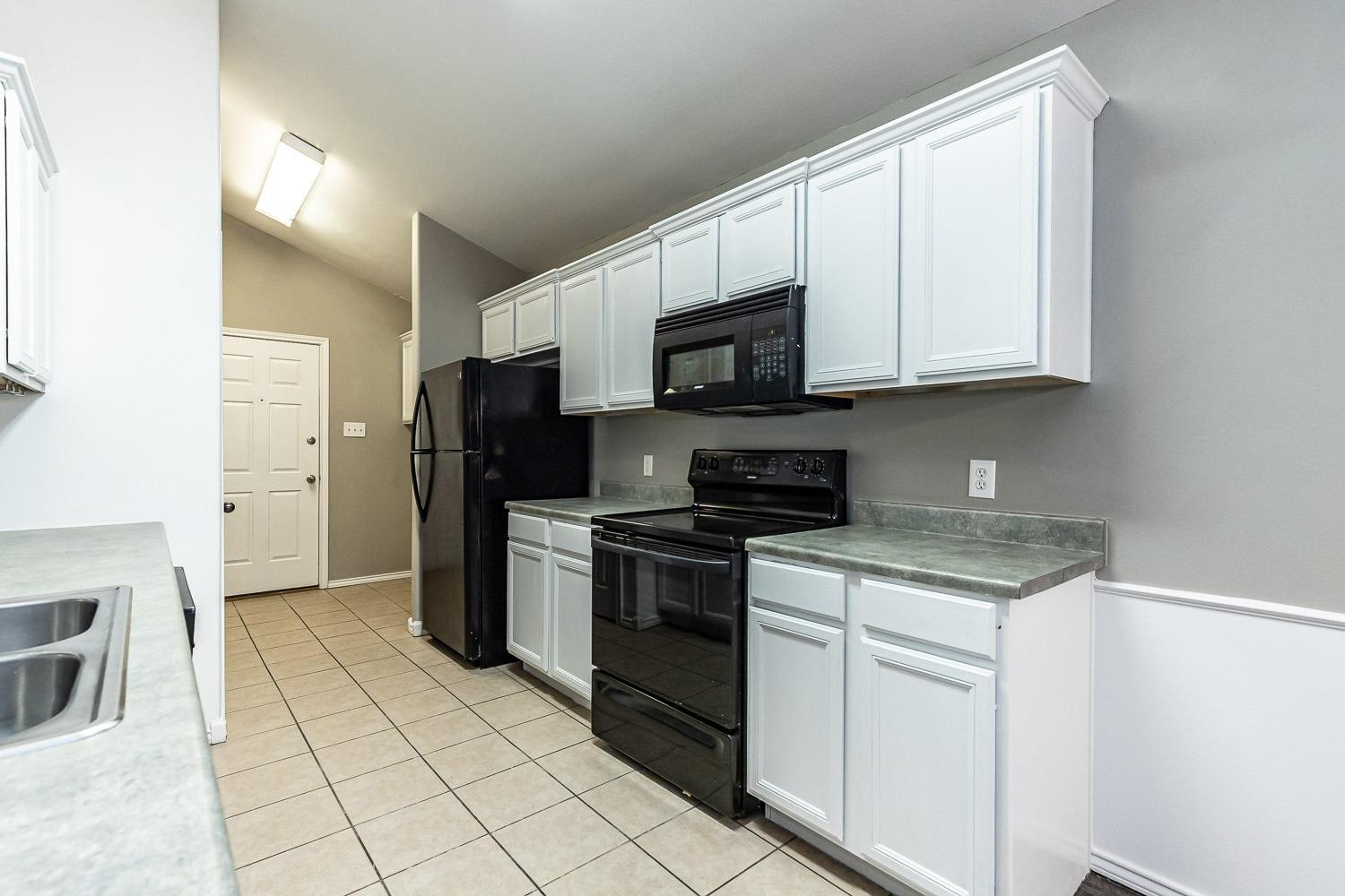 2006 100th Street Lubbock, TX 79423 - Photo 9 of 31 a kitchen with stainless steel appliances granite countertop a stove a sink and a microwave