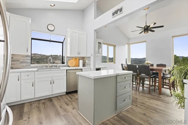 a kitchen with a stove a sink cabinets and wooden floor