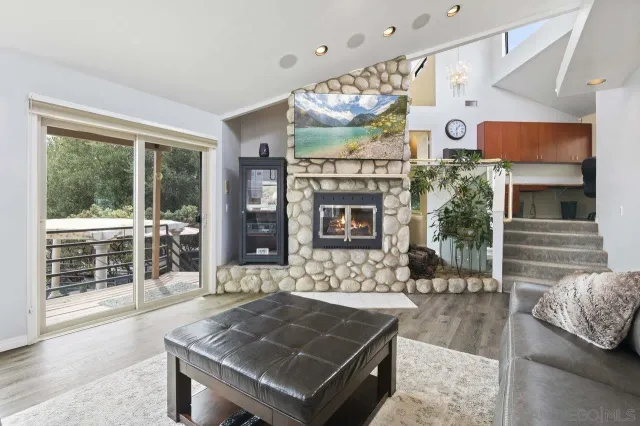 a living room with furniture a flat screen tv and a floor to ceiling window