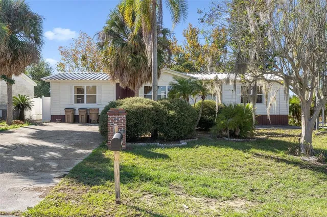 a view of a house with backyard and a tree