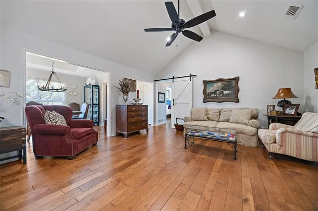 a living room with furniture and a wooden floor