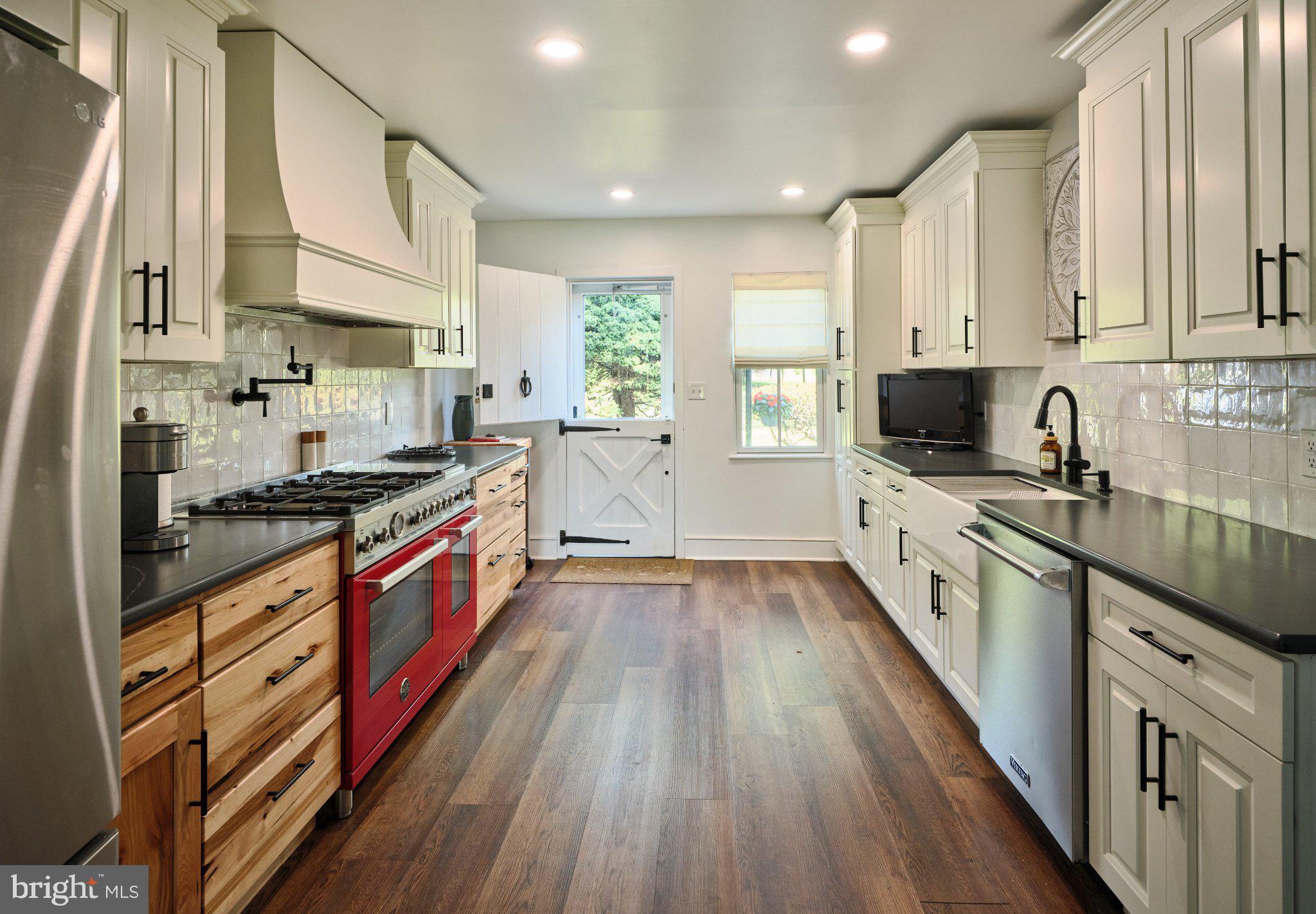 765 Swamp Road Newtown, PA 18940 - Photo 11 of 37 a large kitchen with stainless steel appliances granite countertop a lot of counter space and wooden floors
