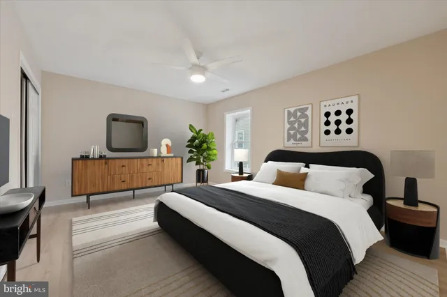 a bedroom with a large bed a flat tv screen and a dresser
