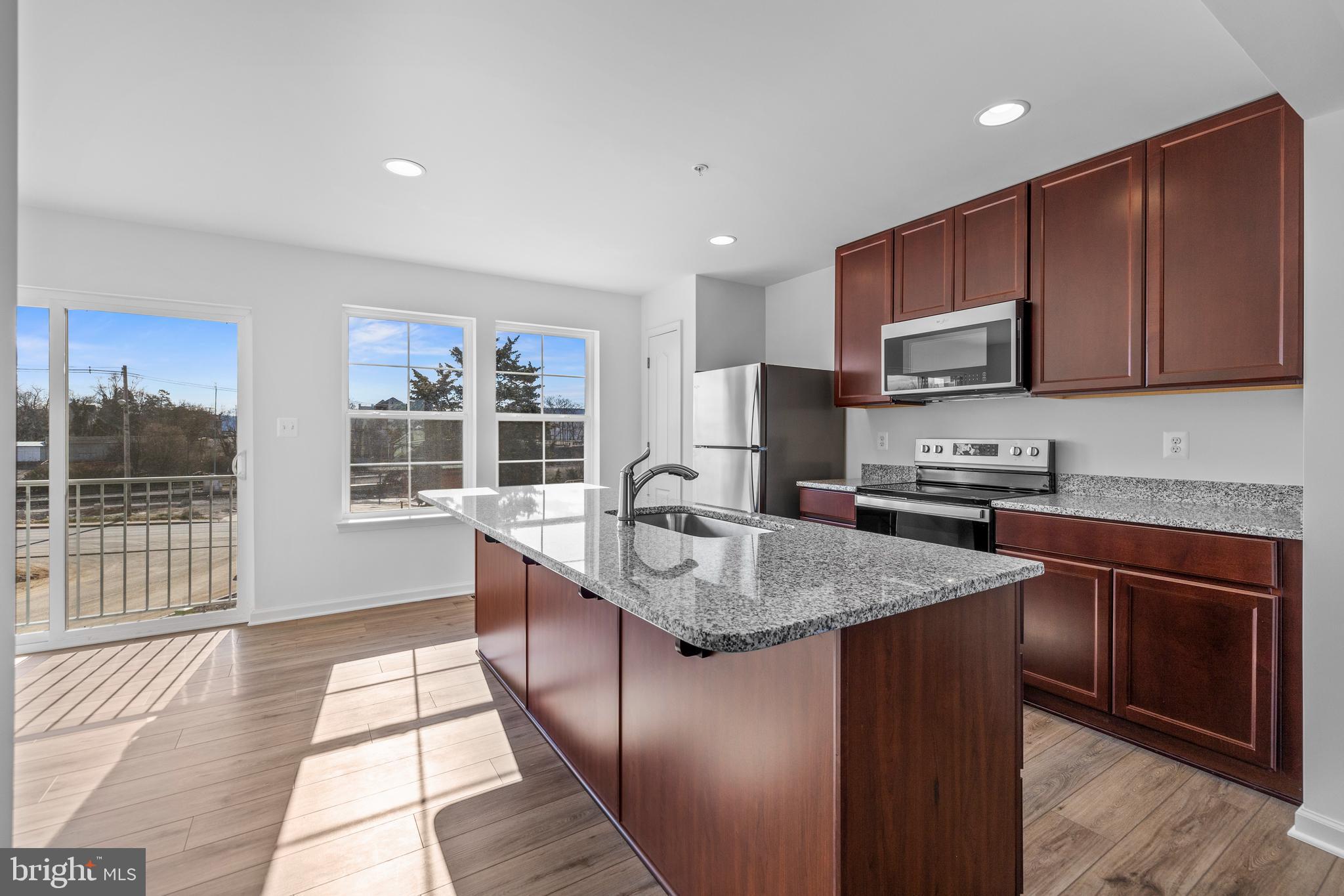 485 Peleton Street Hagerstown, MD 21740 - Photo 7 of 27 a kitchen with stainless steel appliances granite countertop a stove a sink a microwave and a refrigerator