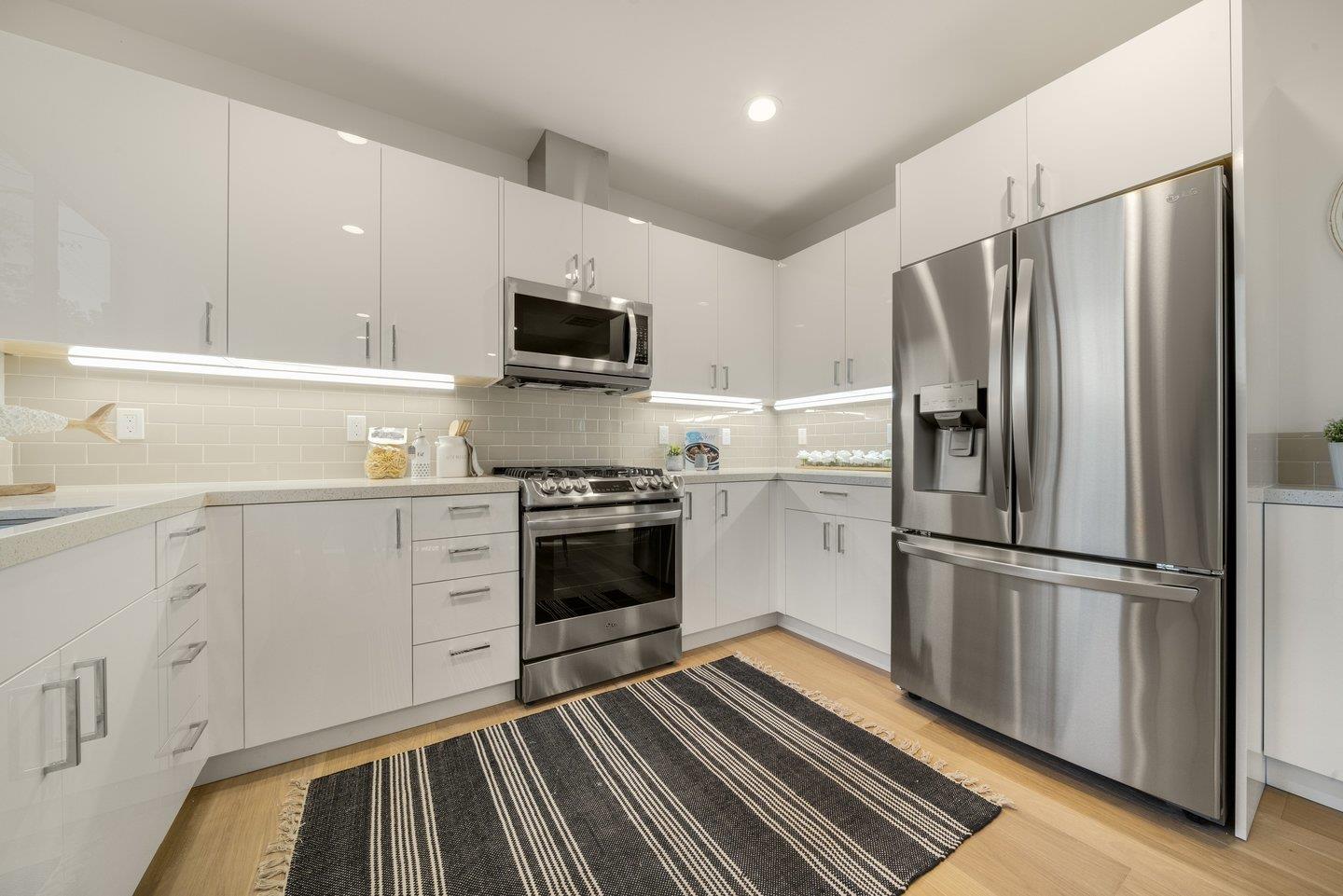 1009 Cascade Drive Sunnyvale, CA 94087 - Photo 62 of 89 a kitchen with white cabinets and stainless steel appliances