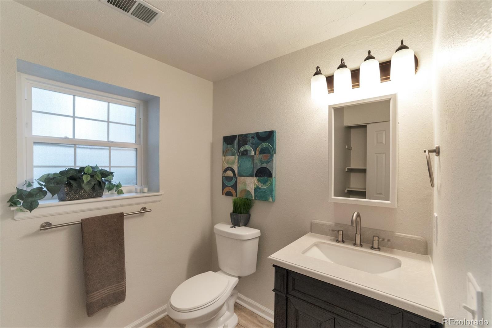 9575 Carr Street Westminster, CO 80021 - Photo 14 of 25 a bathroom with a sink a toilet and mirror