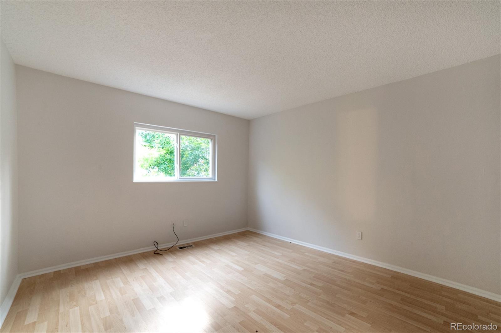 9575 Carr Street Westminster, CO 80021 - Photo 18 of 25 an empty room with wooden floor and windows