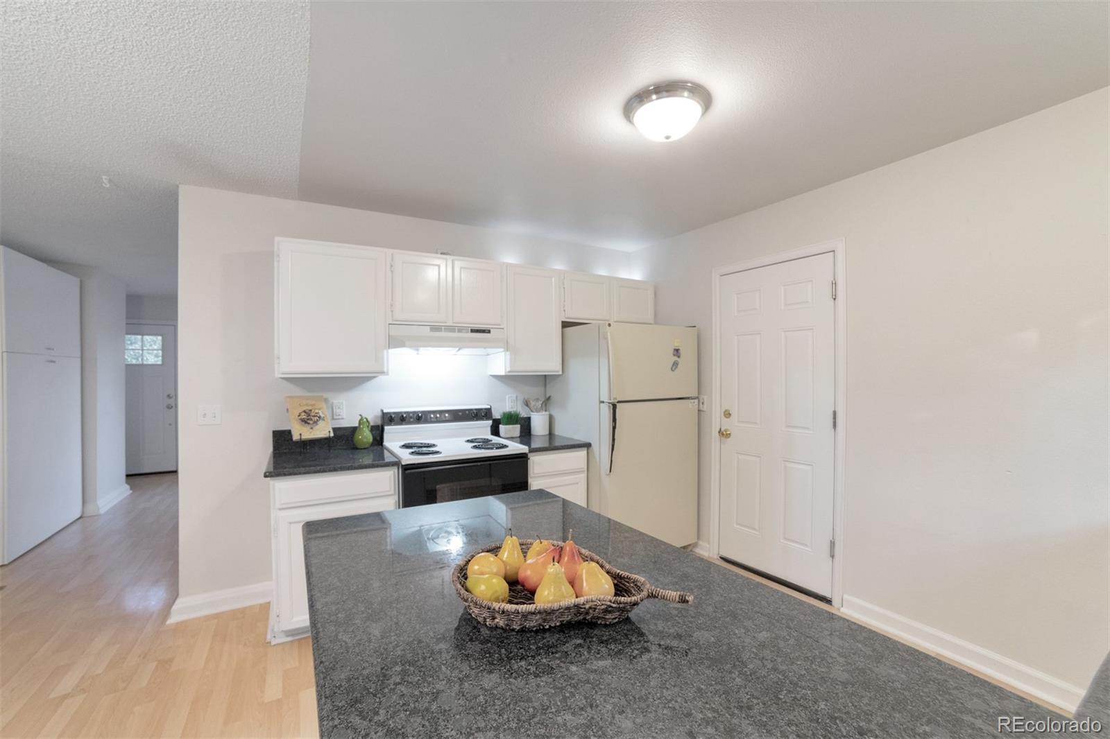 9575 Carr Street Westminster, CO 80021 - Photo 7 of 25 a living room with stainless steel appliances kitchen island granite countertop furniture and a wooden floor