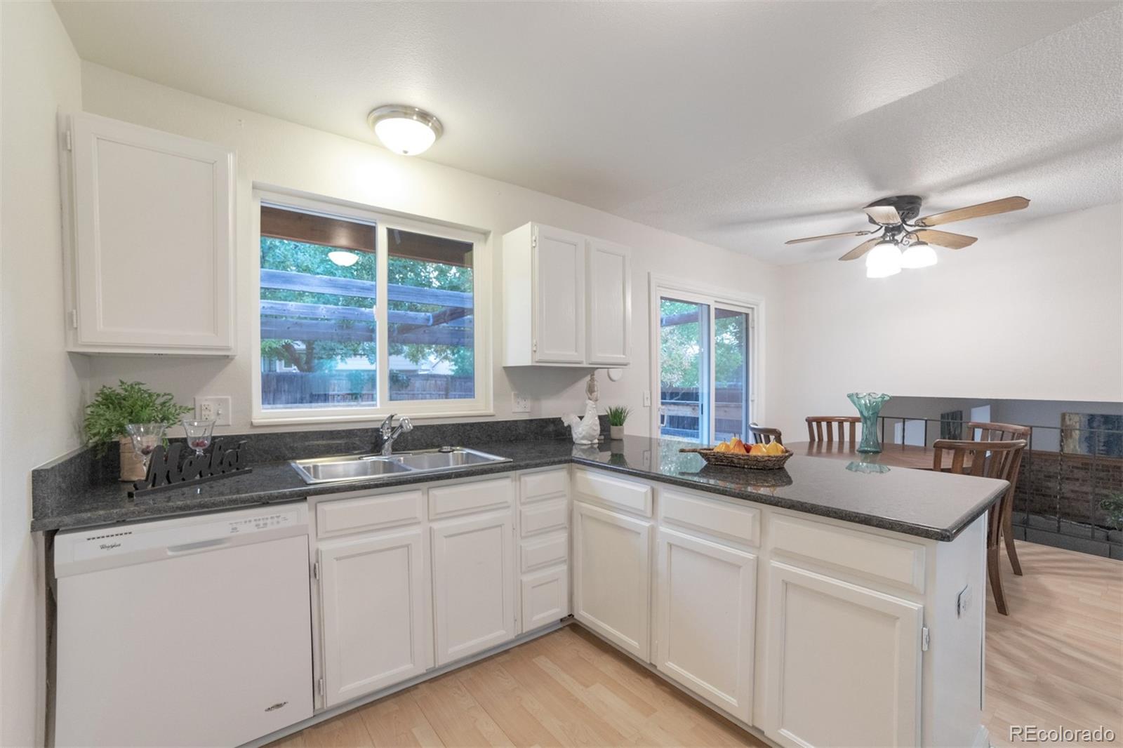 9575 Carr Street Westminster, CO 80021 - Photo 8 of 25 a kitchen with granite countertop a sink and white cabinets