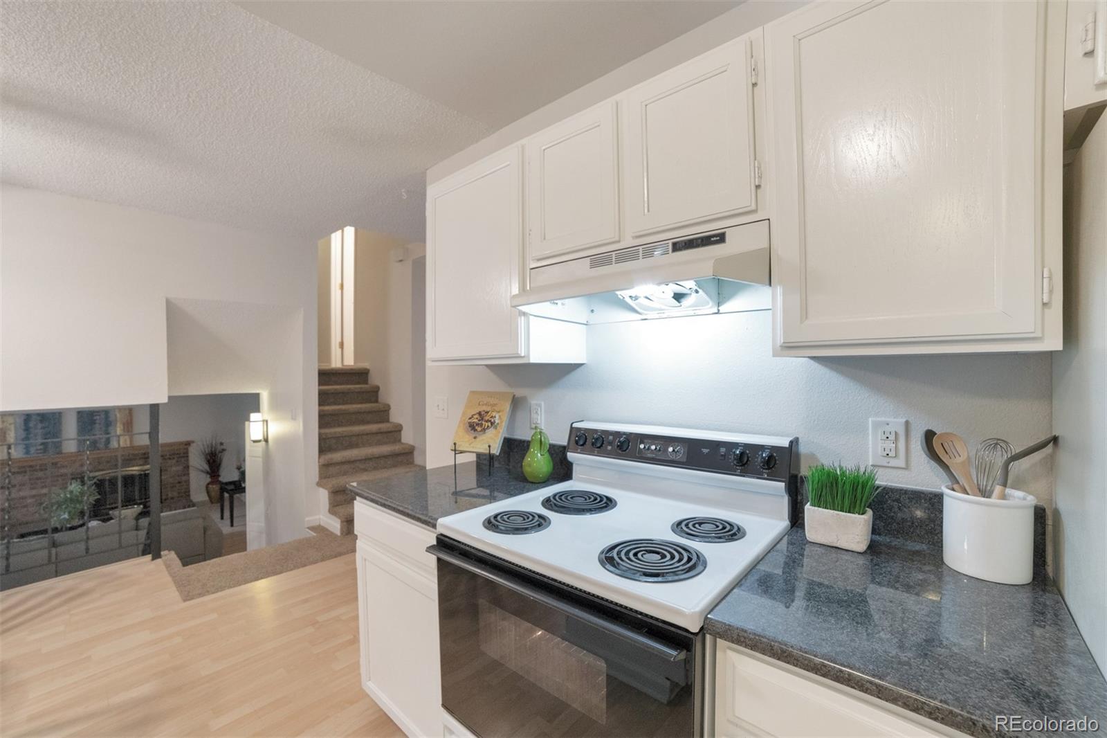 9575 Carr Street Westminster, CO 80021 - Photo 9 of 25 a kitchen with granite countertop a stove and a sink