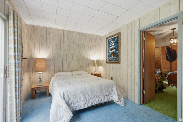 8505 South Snake Crk Road Salt Lake City, UT 84121 - Photo 32 of 67 Bedroom featuring light wood-finish paneled walls, blue carpeting, and a drop ceiling