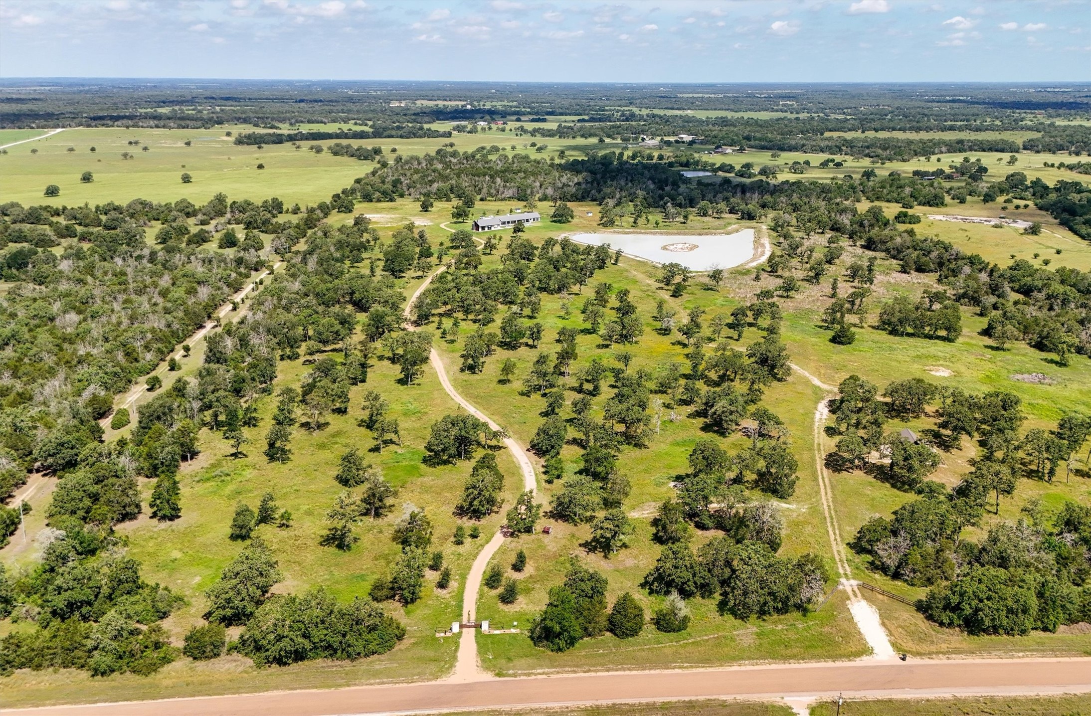 1629 Waldeck Road Ledbetter, TX 78946 - Photo 46 of 50 Aerial view of the property from Waldeck Road. 2 Drive entries, and old abandoned drive on left side of property. Center drive leads to the Main house and Pool house. Right drive leads to The Cottage and pond.