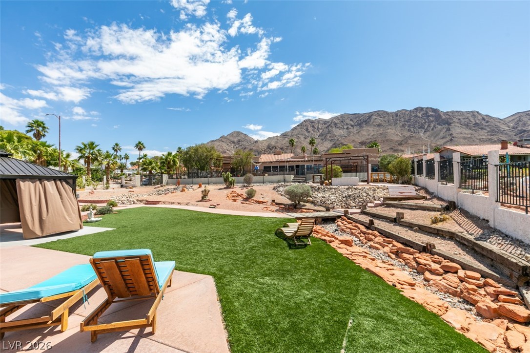 892 North Hollywood Boulevard Las Vegas, NV 89110 - Photo 5 of 81 This serene outdoor space offers a lush green lawn with mountain views, perfect for peaceful enjoyment.