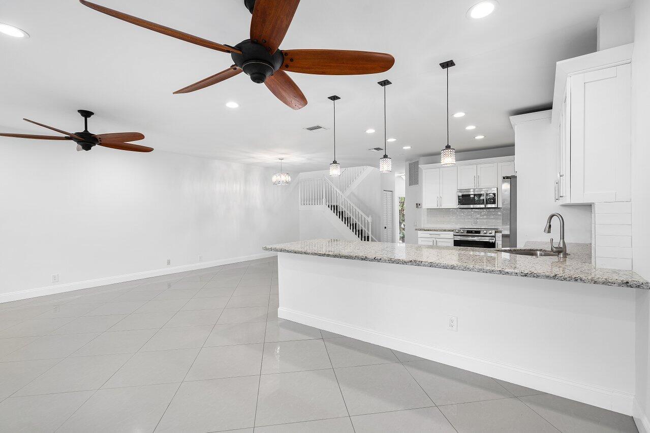 6684 Via Regina Boca Raton, FL 33433 - Photo 5 of 19 a kitchen with stainless steel appliances granite countertop a sink a stove and a refrigerator