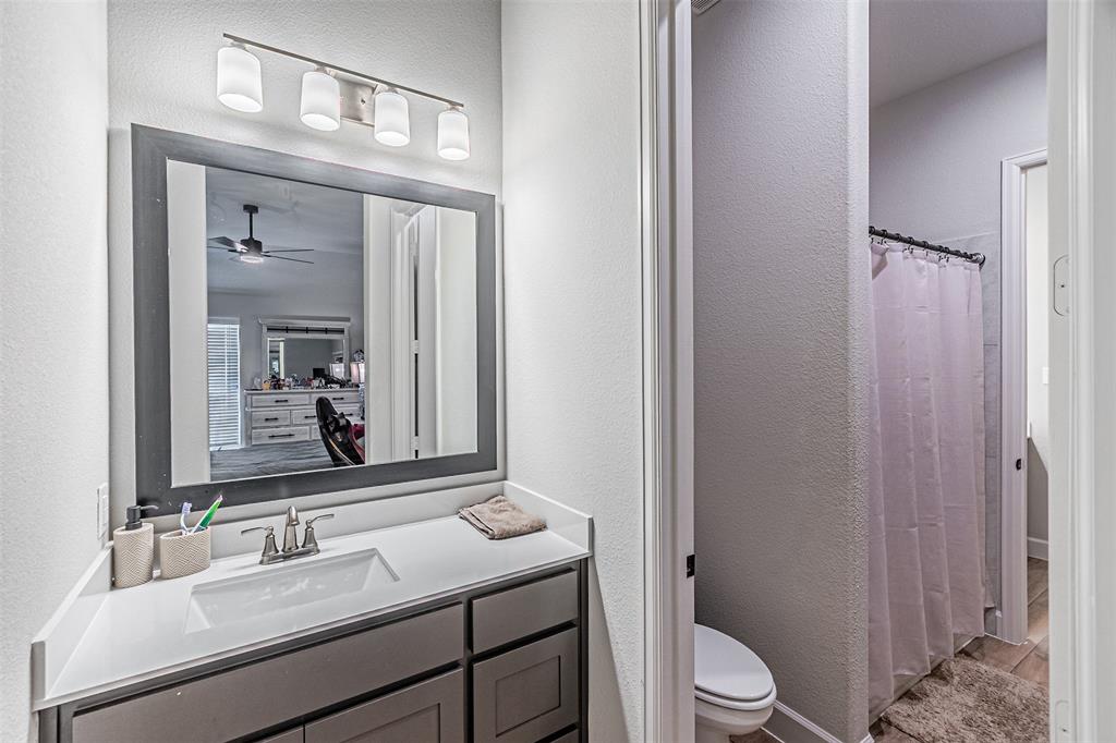 116 Derrett Lane Rhome, TX 76078 - Photo 17 of 30 a bathroom with a granite countertop sink toilet a mirror and shower