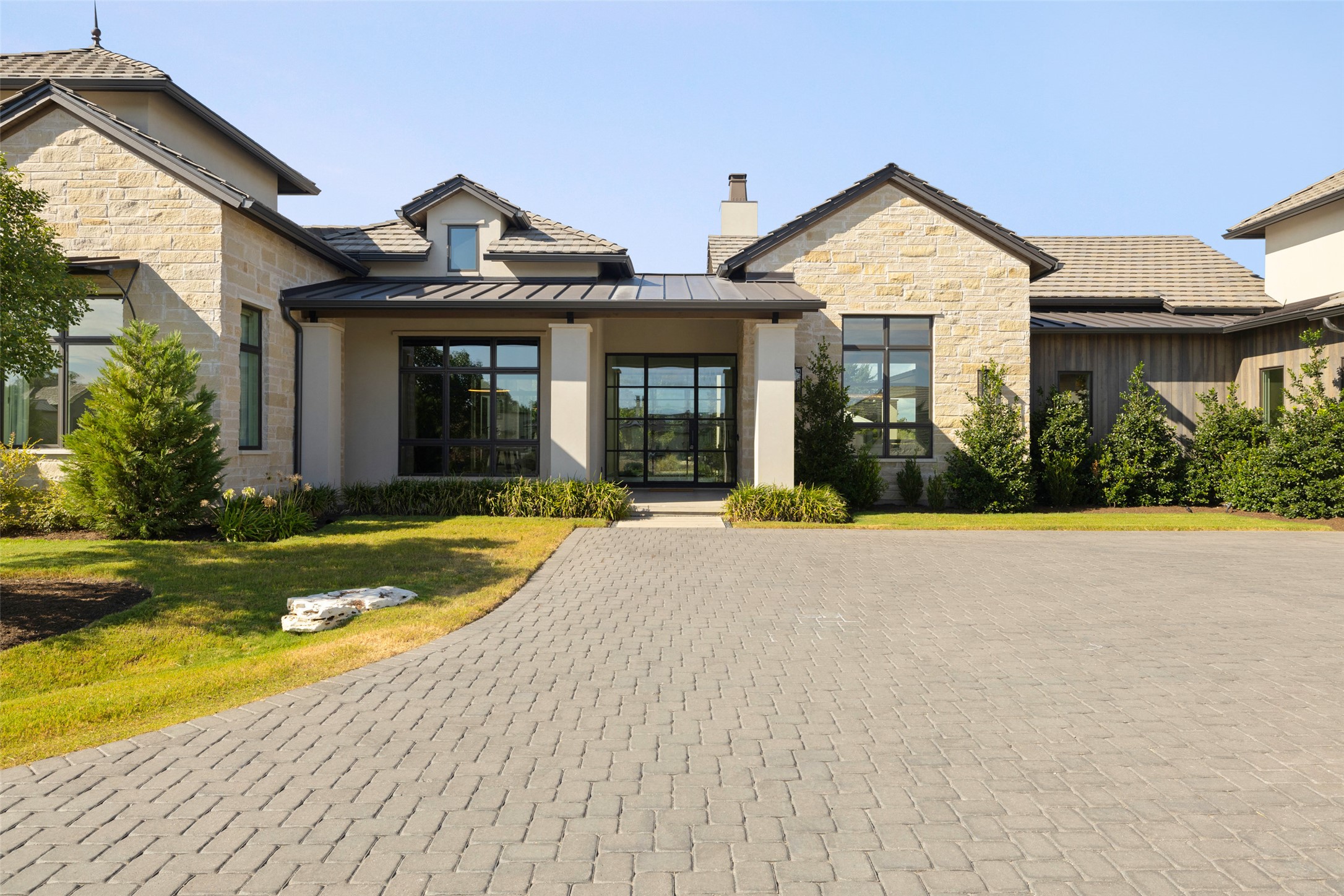 a front view of a house with a yard and potted plants