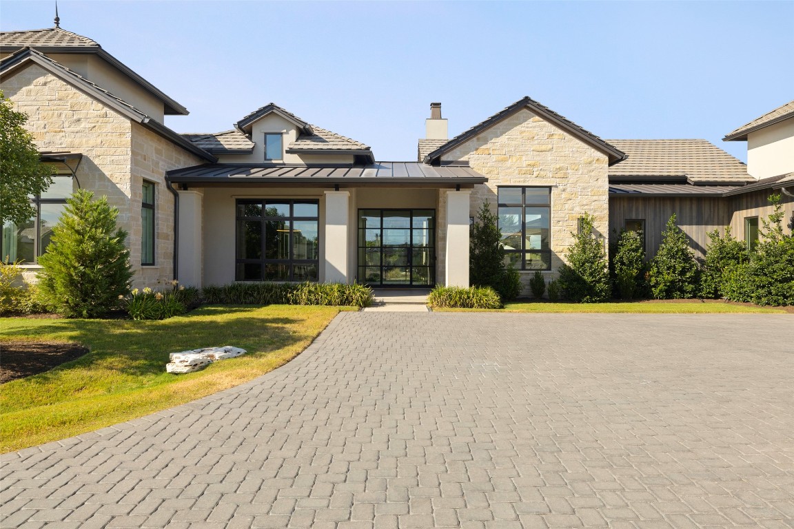 a front view of a house with a yard and potted plants