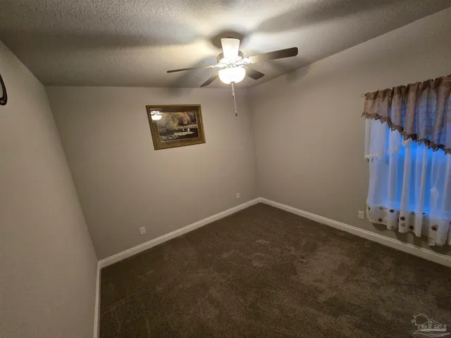 an empty room with a chandelier fan