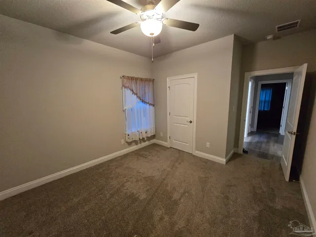 en empty room with closet and a ceiling fan