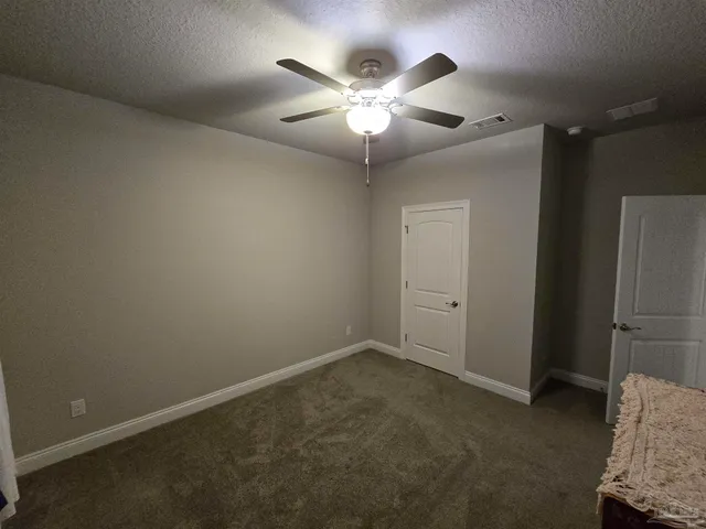 an empty room with closet and fan