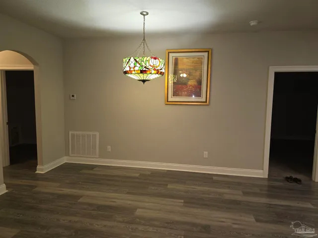 a view of a livingroom with wooden floor a flat screen tv and a window