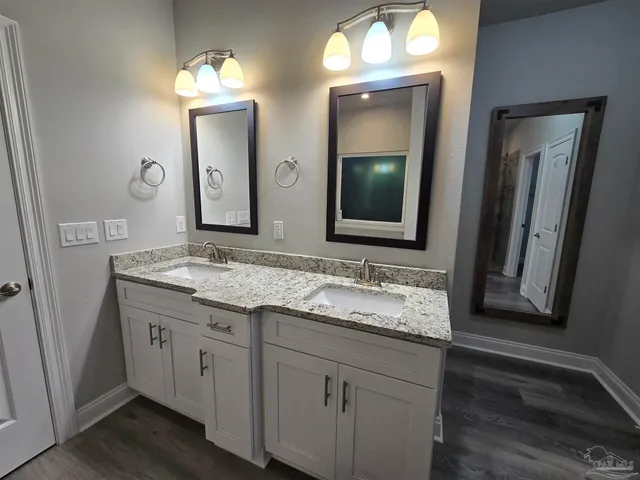 a bathroom with a granite countertop sink vanity and a mirror
