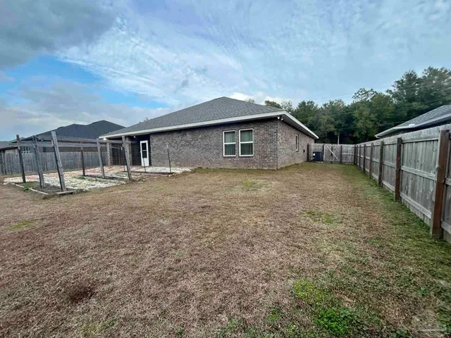 a view of a house with a yard and wooden fence