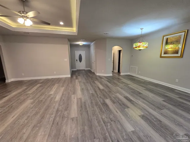 a view of empty room with wooden floor