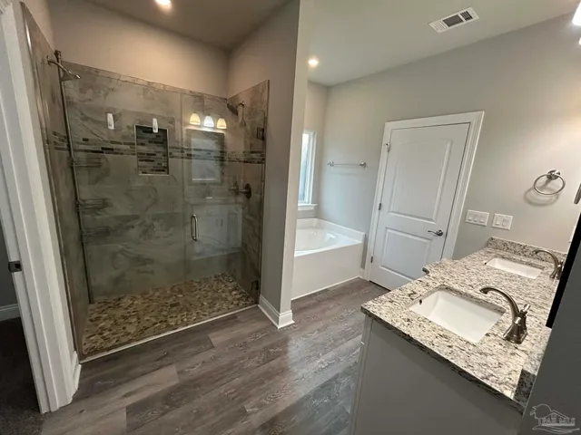 a bathroom with a granite countertop sink a mirror and a shower