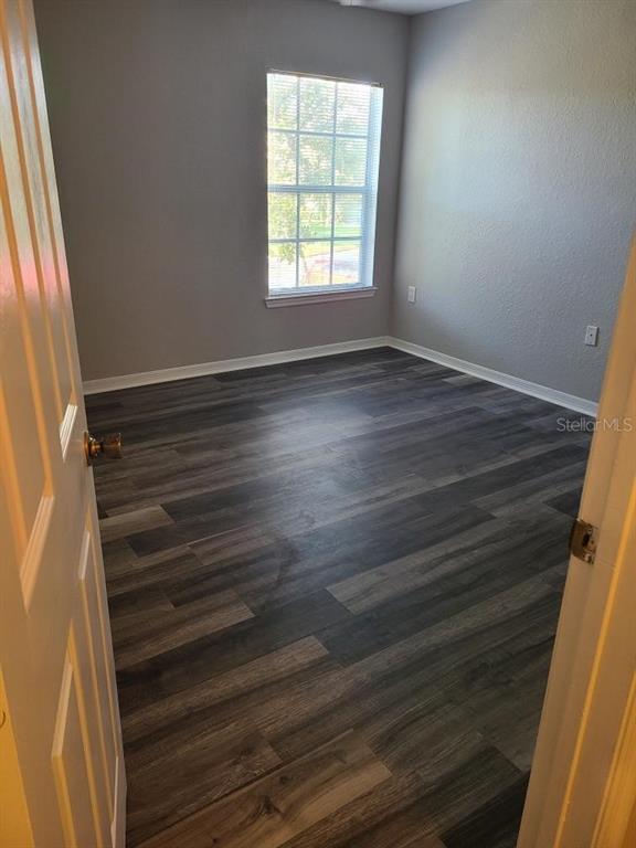 8933 Manor Loop, Unit 202 Lakewood Ranch, FL 34202 - Photo 8 of 17 en empty room with wooden floor and window