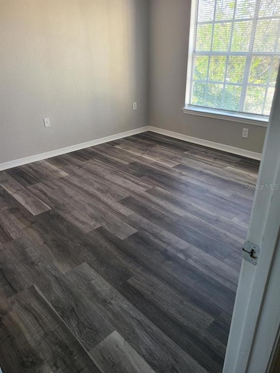 8933 Manor Loop, Unit 202 Lakewood Ranch, FL 34202 - Photo 9 of 17 an empty room with wooden floor and windows