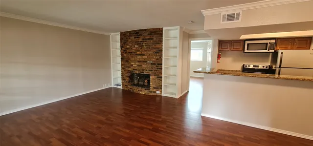 a view of a kitchen with wooden floor and electronic appliances