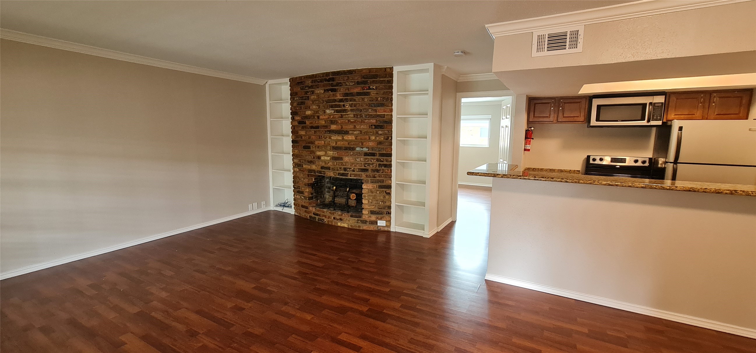 a view of a kitchen with wooden floor and electronic appliances