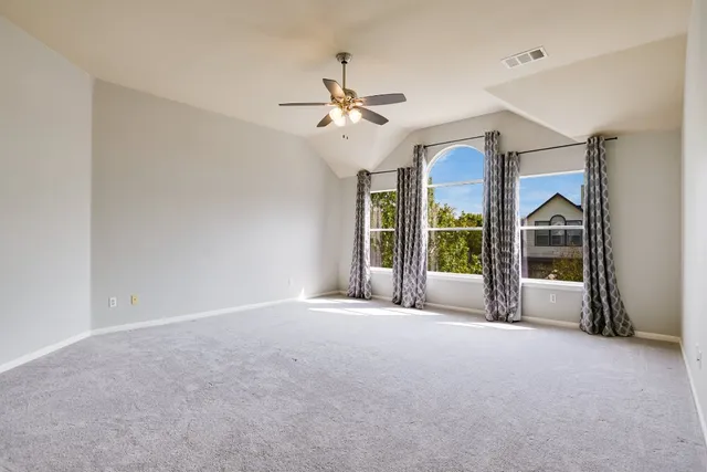 a view of a big room with chandelier fan and windows