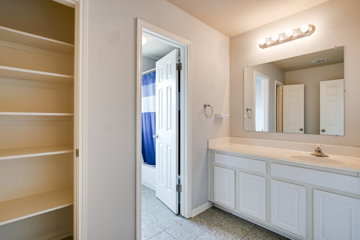 11705 Gold Run Cove Manor, TX 78653 - Photo 15 of 20 a en suite bathroom with a sink and a mirror