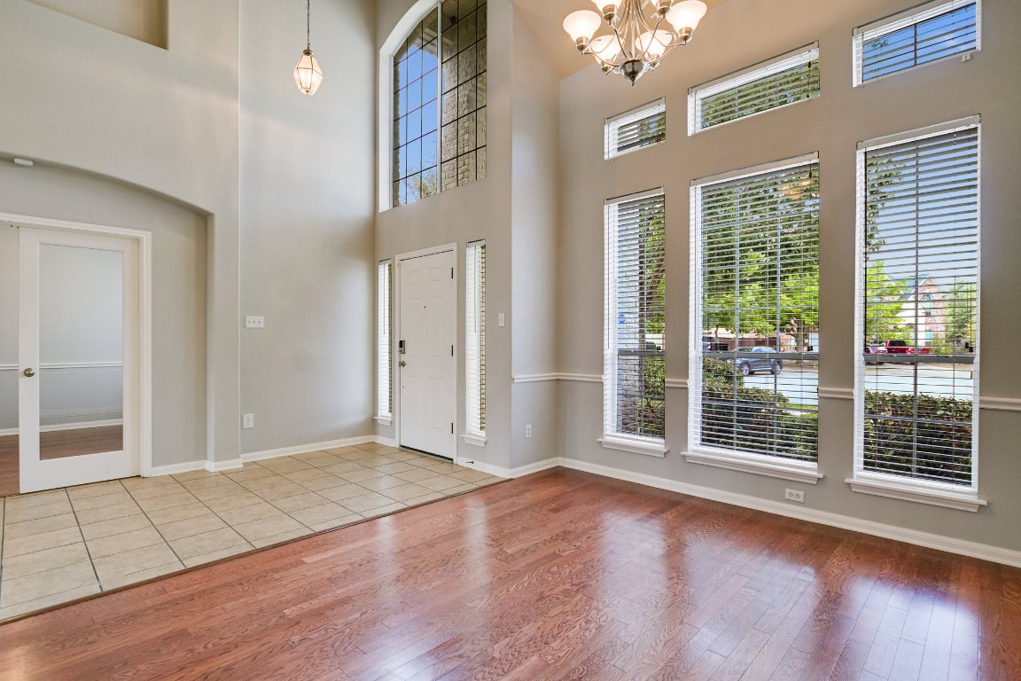 11705 Gold Run Cove Manor, TX 78653 - Photo 3 of 20 an empty room with wooden floor and windows