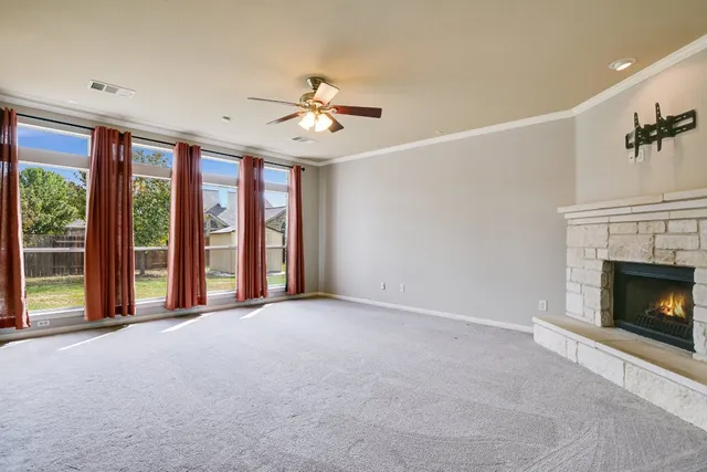 a view of an empty room with a fireplace and a window