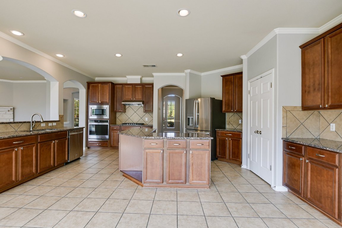 11705 Gold Run Cove Manor, TX 78653 - Photo 9 of 20 a large kitchen with stainless steel appliances lots of counter space and chandelier