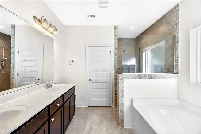 a bathroom with a tub sink and mirror