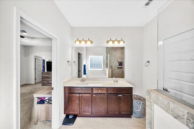 a bathroom with a sink vanity granite tub and shower
